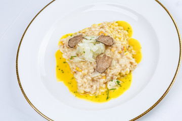Risotto with truffles and corn sauce in white plate