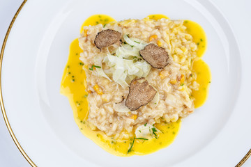 Risotto with truffles and corn sauce in white plate