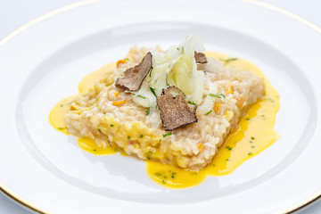 Risotto with truffles and corn sauce in white plate