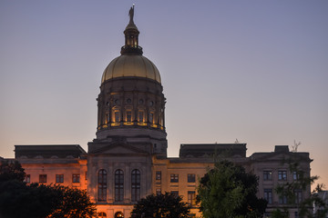 Fototapeta na wymiar Georgia State Capitol Building Lit In Night Sunset Evening Sky With Trees And Lights Downtown That Glow