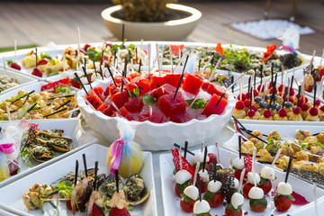 sweet buffet table. Beautifully decorated catering banquet table with burgers, profiteroles, salads and cold snacks. Variety of tasty delicious snacks on the table