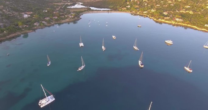 Aerial, beautiful bay in Sardinia and few anchored yachts on sunrise, 4K