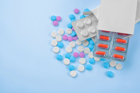 Health care concept. Blister packs with colorful pills on blue background