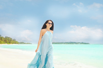 Fototapeta na wymiar Beautiful young woman on sea beach at resort