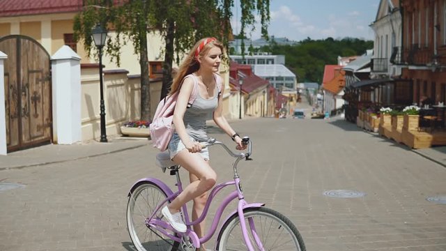 young girl is getting on his bike in the city