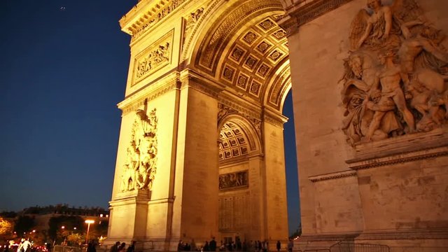 Panorama of tourists under Arch of triumph at night in Paris, France. Arc de Triomphe at the western end of the Champs Elysees and at the center of Place Charles de Gaulle.