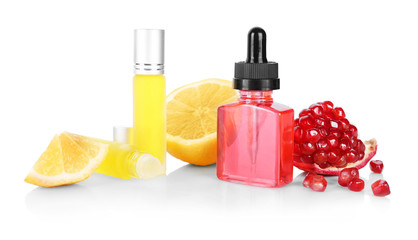 Bottles of perfume and fruits on white background