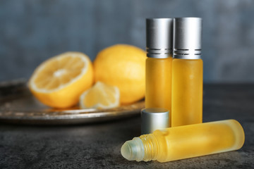 Bottles of perfume and blurred lemons on background