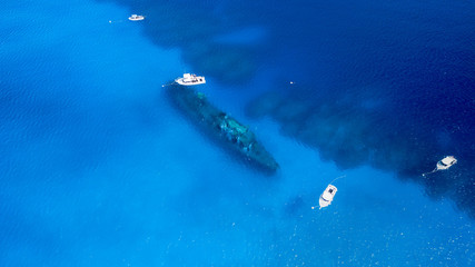 Dive boats over a large shipwreck in clear, blue, tropical waters