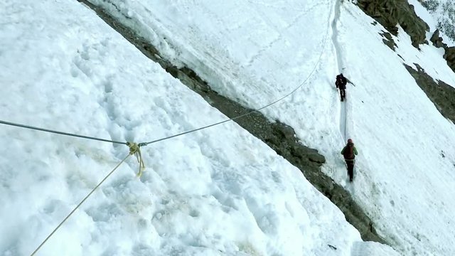 mountaineering climbers on mont blanc passing the most dangerous par of couloar
