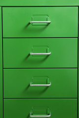 Green cabinet with metal handles, closeup
