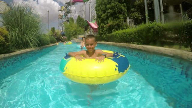 Happy boy enjoy aqua park rubber swimming in 