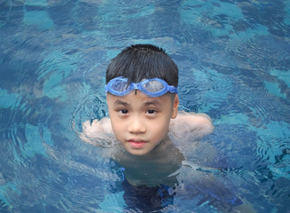 Asia boy kid child nine years old in swimming pool. Outdoor view