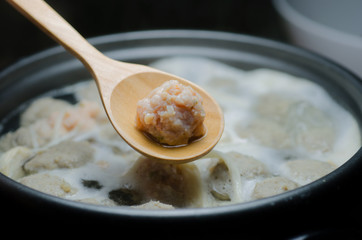 Pork in a wooden spoon on a Suki pot