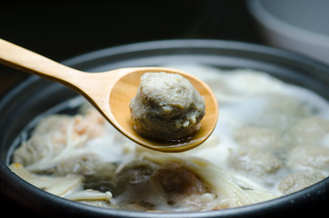 Meat balls in a wooden spoon on a Suki pot