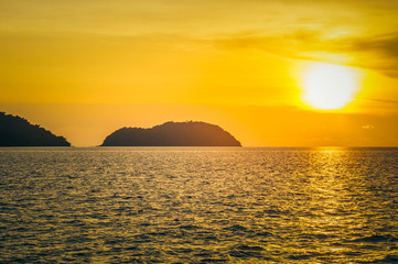 Beautiful blazing sunset landscape at black sea and orange sky above it. Amazing summer sunset view on the beach.