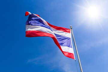 Thai flag of Thailand with blue suumer sky sunny day background.