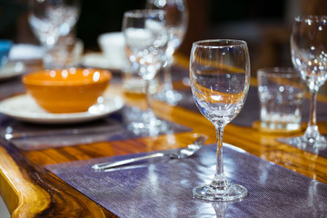 Close-up empty wine glasses on wooden table. Part of dining table interior