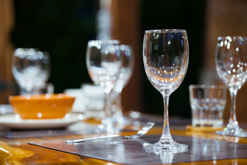 Close-up empty wine glasses on wooden table. Part of dining table interior