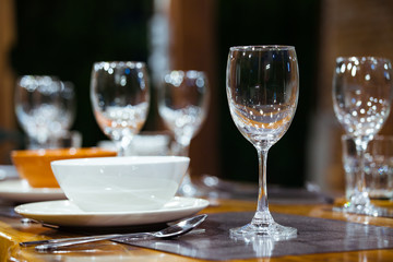 Close-up empty wine glasses on wooden table. Part of dining table interior