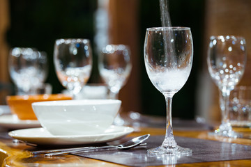 Close-up wine glasses on wooden table. Part of dining table interior