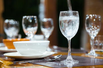 Close-up wine glasses on wooden table. Part of dining table interior