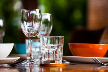 Close-up empty wine glasses on wooden table. Part of dining table interior