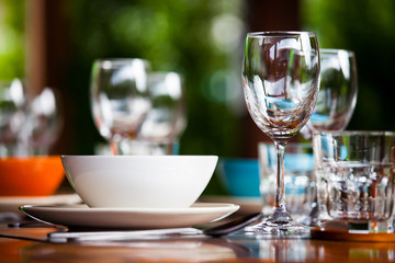 Close-up empty wine glasses on wooden table. Part of dining table interior