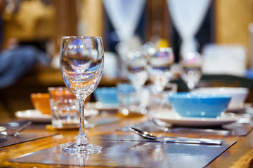 Close-up empty wine glasses on wooden table. Part of dining table interior