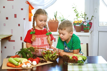 Children prepare salad vegetables . Happy kids in the kitchen . The concept of a healthy wholesome food