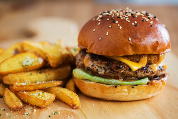 chicken burger and french fries on wooden board