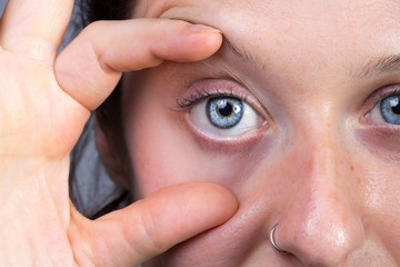 Woman widening her eye with her fingers