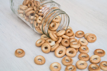 Mini bagels Russian baranka in glass jar on white gray wood background