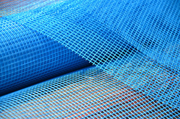 Close-up texture of a blue reinforcing mesh rolled up in a roll. Building resource for reinforcing...