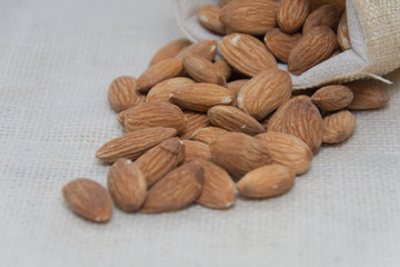 Burlap sack with almonds spilling out