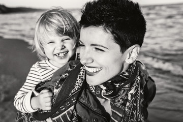 Closeup group black and white portrait of Caucasian mother and daughter baby girl smiling laughing...