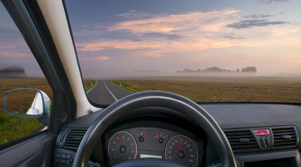 A view of the cockpit of a car driving .The way in the morning.