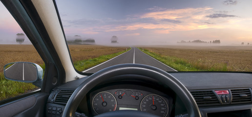 A view of the cockpit of a car driving .The way in the morning.