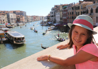 Fototapeta na wymiar Pretty little girl above the Rialto bridge in Venice in Italy an