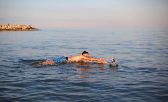 boy plays water polo in the sea