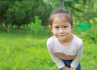 Portrait of little girl posting in the garden.