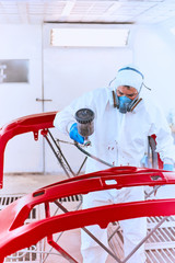 Painting bumpers machine red in the paint shop.