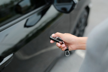 woman hand using interlock remote to open door of a car.