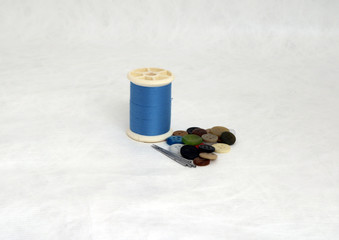 Blue thread and colorful button and pin isolated on white background. Its is a garment accessories.