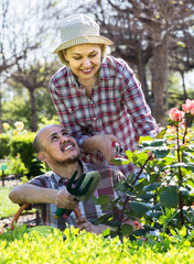 portrait of a  couple taking care of green plants in the garden
