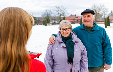 Happy elderly couple and young caregiver