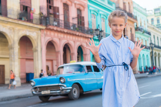 Adorable little girl in popular area in Old Havana, Cuba. Portrait of cutiest kid outdoors on a street of Havana