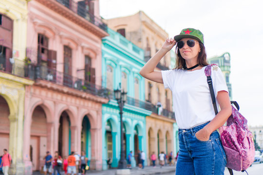 Young woman in popular area in old Havana, Cuba. Beautiful girl traveler background colorful houses in the city