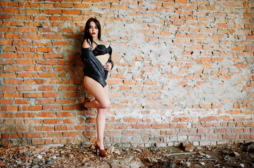 Brunette plus size sexy woman, wear at black leather jacket, lace panties, bra at abadoned place...