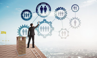 Businessman on house roof presenting teamwork and connection concept. Mixed media
